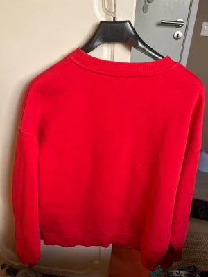 Röd sweatshirt från Lindex XS - En enkel och snygg röd sweatshirt från Lindex i storlek XS. Tröjan har rund halsringning, långa ärmar och ribbade muddar vid ärmslut och nederkant. Perfekt för en avslappnad och trendig look.