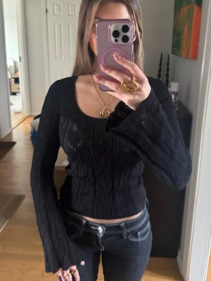 Svart topp - En svart snygg topp med utsvängda ärmar nere vid händerna, sitter snyggt och tajt i midjan 