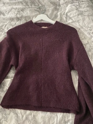 Vinröd stickad tröja Gina Tricot - Vinröd stickad tröja från Gina Tricot med rund halsringning och långa ärmar. Tröjan är figursydd 