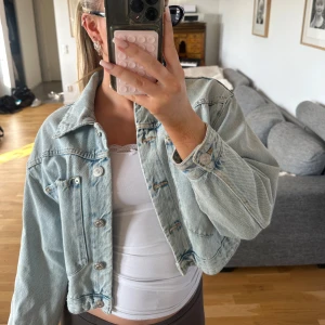 Ljusblå  jeansjacka Zara - Trendig ljusblå jeansjacka från Zara. Klassisk modell med bröstfickor, silverfärgade knappar och avslappnad passform. Inga defekter.