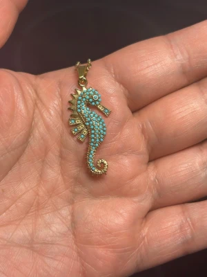 Halsband med sjöhäst  - Säljer en elegant och tunn ring med kedjedesign i guldpläterat material. Ringen har en enkel och stilren form som passar perfekt för dig som gillar minimalistiska smycken. Perfekt att bära ensam eller att kombinera med andra ringar.