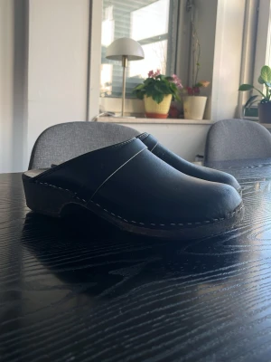 Svarta klassiska trätofflor - Säljer mina svarta träskor som jag inte passar längre. De är storlek 41-42 ungefär och jag har 44 och passar de lite men på gränsen och därför säljs de. Ny rengjorda inuti men som man ser är de lite använda när man kollar under men annars är de fräscha.  