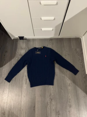 Mörkblå stickad tröja Polo Ralph Lauren - Säljer en mörkblå stilig polo Ralph lauren tröja. Pris kan diskuteras vid snabb affär! Storlek L men skulle säga att den är liten i storleken då den inte passa mig.