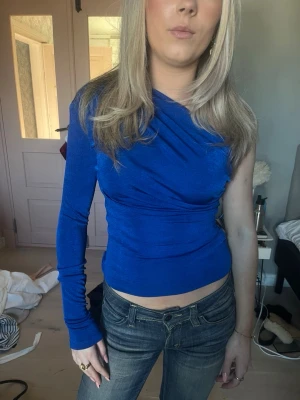 Blå oneshoulder topp med axelvaddar  - Snygg marinblå oneshoulder topp med lång ärm på ena sidan och axelbandslös på andra i stretchiga tyg. Storlek S och har en axelvadd🙌🏼