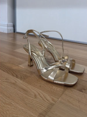 Guld klackar  - Klackar, aldrig använda & köpta i Italien. Strl 37, men passar mig som är 38 också. Säljer pga jag ej använder klackskor. Pris går att diskuteras vid snabbaffär