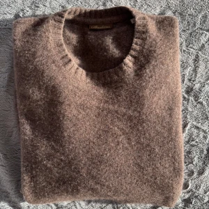 kashmirtröja från Stenströms - Säljer en lyxig brun tröja i 100% kashmir från Stenströms. Tröjan har en klassisk rund hals och långa ärmar, perfekt för kyliga dagar. Den mjuka kashmiren ger en exklusiv känsla och stil. Passar perfekt för både vardag och mer uppklädda tillfällen. Bara att höra av sig till oss vid minsta fundering😁