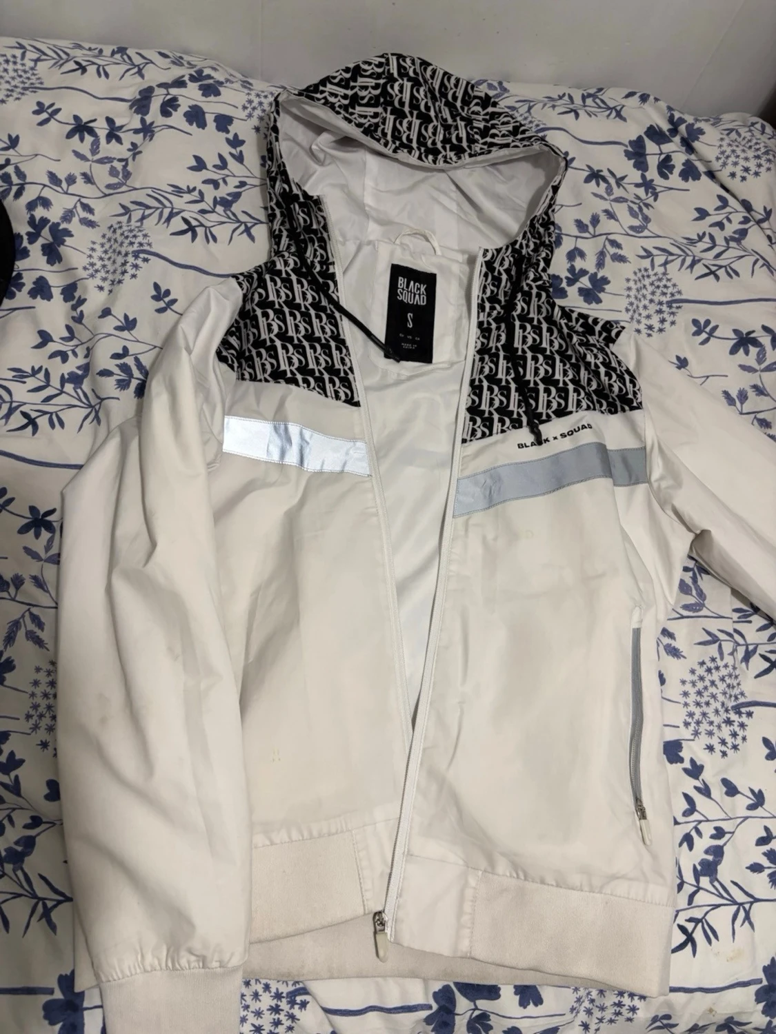 Vit vindjacka med mönstrad huva