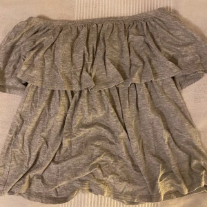 Tube topp Gina Tricot S - Fin skön grå tube topp med volang som knappt använts. 95% viskos 5% elastan