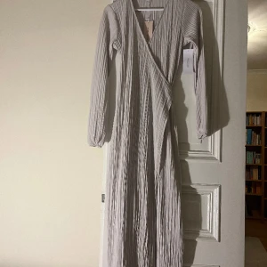 Klänning - Helt ny klänning från bubbelroom, fin och festlig. Aldrig använd, prislappen finns fortfarande kvar. Gråvit