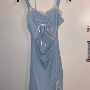 Ljusblå klänning med spets - Fin klänning till vår och sommar med spets, rosett och ruching framtill. Passar 36-38