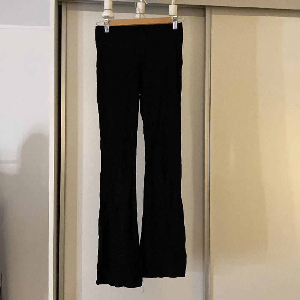 Fina utsvängda svarta byxor från Gina Tricot Young med tjock kant vid midjan. Köpta för 200kr, säljer för 49kr. Jeans & Byxor.