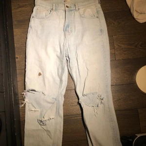 Ljusblåa ripped jeans - Ljusblå, högmidjade ripped knä jeans, med ett litet hål på baksidan och en fläck på framsidan.