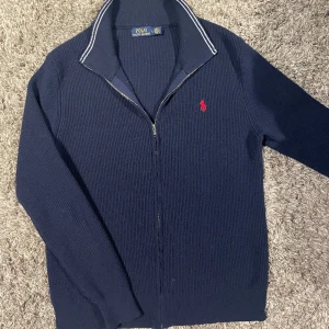 Ralph Lauren Fullzip - En skitsnygg stickad Ralph lauren fullzip i nyskick. Storlek L men passar även M. Bara att skicka ett DM vid intresse! 
