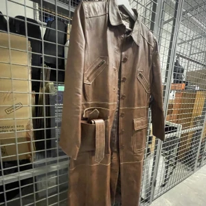 En brun läder kappa - En jättefin och lång läder kappa i bra skick storlek 40