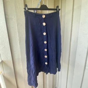 Linnekjol med stora träknappar - En vadlång linnekjol med stora träknappar framtill 