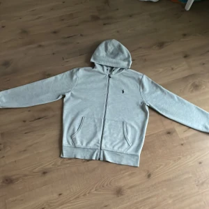Ralph lauren zip hoodie - Säljer min polo zip hoodie eftersom den är för stor för mig, den har inga stora defekter men snöret runt luvan saknas men kan fixa men annars är den i bra skick, nypris 2200kr mitt pris 700 1/3 av ny priset, modellen är runt 177 oh 60 kg