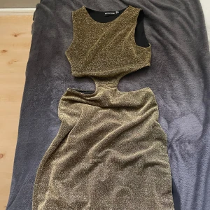 Guld glittrig lång klänning - Storlek EU 34, aldrig använd pågrund av förliten storlek och lång, då den ej kommit till användning. Från pretty little thing, vet tyvärr inte ursprung priset.   