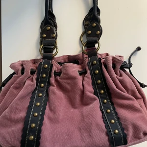 Rosa väska - Rosa ”Manchester” väska med guld detaljer💖superfin men kommer inte till användning🩵 köpt secondhand så det finns tecken på användning men överlag bra skick