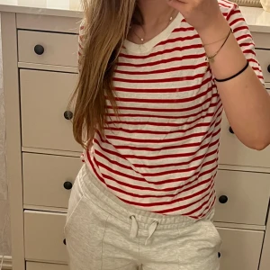 Randig t-shirt - Jag säljer en röd vit randig t-shirt från zara. Tröjan är lite missfärgad uppe vid nacken som den sista bilden visar, dock inget som syns när man har den på. Jag skulle säga att tröjan har M i passform.
