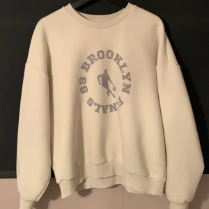 Beige Oversized Sweater med basket tryck från Gina Tricot - Extremt skön och mjuk oversized sweater som enbart testats. Säljer då den tyvärr inte kommer till användning. Tröjan är i storlek L då jag valde att gå upp flera storlekar för att den skulle bli oversized.