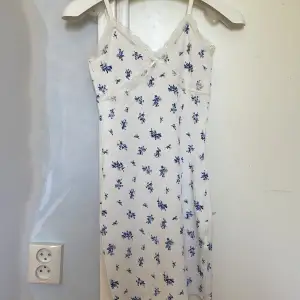 En jätte fin vit klänning med blå blommor. Säljer pga den aldrig har kommit till användning och är nu för liten. Prislapp finns kvar, köpt för 149