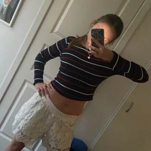 Randig långärmad tröja - Svart långärmad tröja med röda och vita ränder, vet inte vart ifrån men det står ”New Look” på den, ganska kort i magen.
