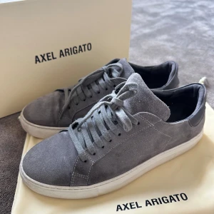 Gråa mocka skor Axel Arigato  - Riktigt snygga Axel Arigato skor i mocka🔥 köpta för 2250 på nk i Göteborg förra våren (kvitto finns på sista bilden). Allt og ingår, box o dustbag! Använda under två månader innan dem blev för små och sen dess har de bara legat i dustbagen🤝