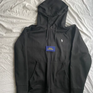 Helt ny Ralph Lauren zip Hoodie - Säljer denna helt nya Ralph Lauren zip hoodie i strl L fast passar M. Denna säljs eftersom jag ryckt av lappen och därmed inte kan lämna igen den. Skriv vid frågor!
