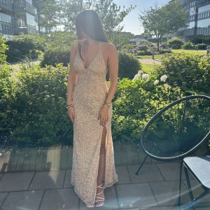 Balklänning - Säljer nu min superfina balklänning i färgen ljusguld men skimrar lite mot gammelrosa med släp & paljetter. Den har även justerbara axelband & lårhög slits samt djup rygg.  Klänningen är helt ny & oanvänd så lappar finns kvar, skriv för fler bilder💓