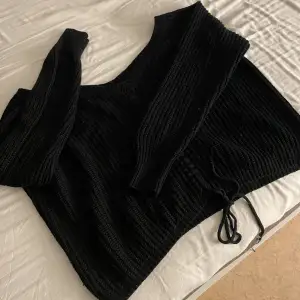 Mjukare stickad tröja där du kan justera längden på magtröjan