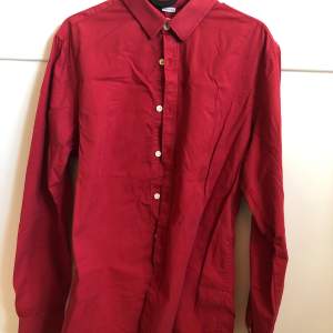 En röd skjorta köpt på secondhand. Unisex. Skjortan är i gott skick, men jag är osäker på hur mycket den är använd då jag inte ägde den först. Säljer för under 100kr!!!
