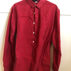 En röd skjorta köpt på secondhand. Unisex. Skjortan är i gott skick, men jag är osäker på hur mycket den är använd då jag inte ägde den först. Säljer för under 100kr!!!
