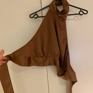 Haltertopp brun - En jättefin topp från Bikbok i bra skick, öppen rygg, hög hals och en perfekt festtopp 🥳