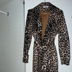 Leopardmönstrad trenchcoat - En leopardmönstrad trenchcoat i skönt material. Strl M. Knyt i midjan.