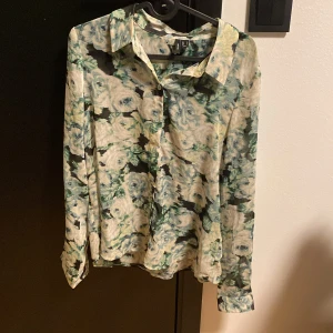 Blus - Vacker blus med blomm motiv, i princip oanvänd.