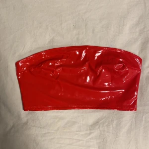 Tubetopp - Typ latex material. Vacker röd färg och materialet är stretchigt. Insidan är i tyg.