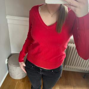 Röd stickad tröja med v-ringning. Mycket bra skick. Den är i storlek M men passar mig som brukar ha S så skulle säga att det är mer som en storlek S.💕