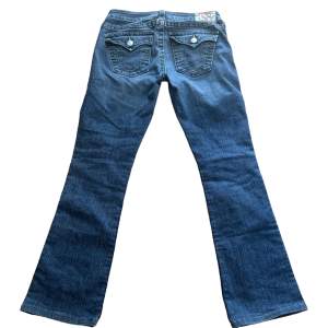 snygga true religion jeans. Model: Becky. W28. Lågmidjade och bootcut. Mått: Midja: 38 cm, Längd från gren upp till midja: 19 cm, Innerbenslängd: 78 cm. 