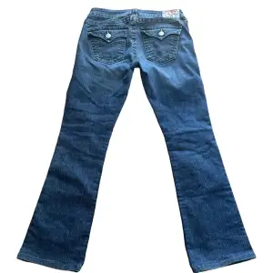 snygga true religion jeans. Model: Becky. W28. Lågmidjade och bootcut. Mått: Midja: 38 cm, Längd från gren upp till midja: 19 cm, Innerbenslängd: 78 cm. 