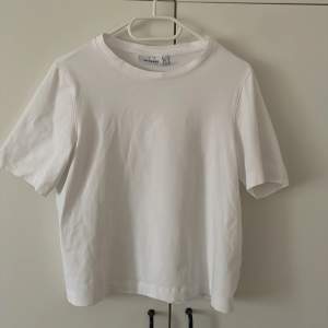 Vit basic t-shirt i en bagy modell, köpt i storlek XS så den är som en storlek M ungefär. Bra skick och inga defekter. 