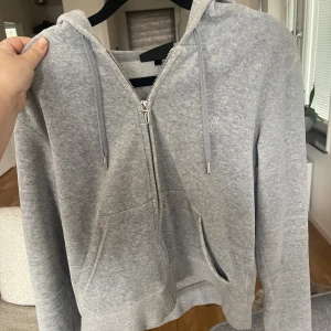 Grå Juicy couture kofta  - Koftan är ljusgrå,  i storlek medium (M). Jätte bra skick, har bara haft på mig den några gånger. Köptes från Jackie för 1300kr och jag säljer den för 700kr. (Lite skrynklig just nu för den har legat i garderoben), skriv gärna för fler bilder