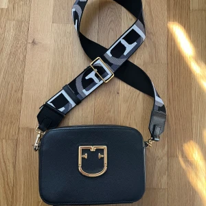 Furla väska - Ca 20x15 cm i storlek, bandet går att justera och byta ut. Väldigt fint skick, endast lite nött vid metallen på slutet av banden. Nypris 2800kr.