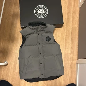 Black label canada goose väst - En nästan helt ny black label Canada goose väst köpt från Canada Goose hemsida. (Digitalt kvitto finns) köpt för cirka 5600 kr och den är i storlek L. Perfekt för småkyligt väder och Perfekt för o vakta centrum eller grischa i stan o se maskulin ut.
