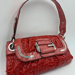 Rosa/röd guess väska - Äkta guess väska med längre band och dustbag! (Finns några få svarta streck inuti väskan men inget man tänker på) Nästan som ny!