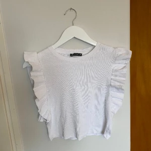 Volangtopp - En vit volangtopp från Zara i ribbat tyg. Fint skick då den inte är så använd, storlek S💞