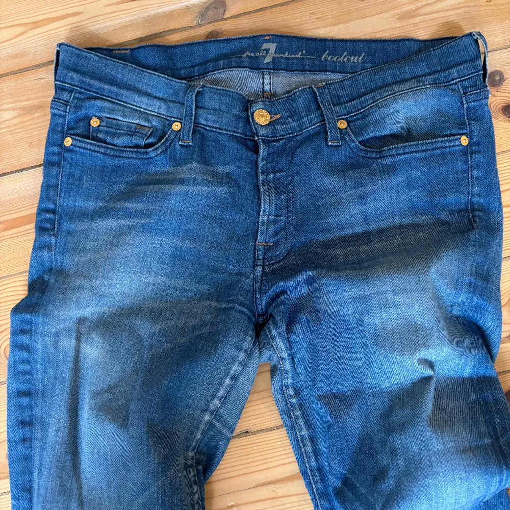 Blåa Bootcut jeans från 7 for all mankind.  Fin tvätt (något ljusare blå), med lite slitningar vid hälen.   Använda men gott skick (bortsett från slitningarna).   Storlek 32. . Jeans & Byxor.