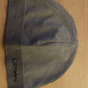 Grå Kalenji beanie  - Helt ny Kalenji mössa(grå) Kan användas till livsstil och träning. Mjuk i materialet och enkel att tvätta. Samt en snygg passform på huvet.  Går o mötas upp o skickas,  Hör gärna av dig vid intresse.