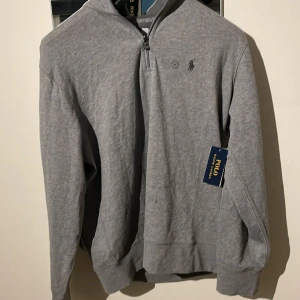 Ralph Lauren Halv Zip - Säljer nu min riktgt snygga Ralph Lauren tröja i färgen grå. Tröjan är helt ny och aldrig andvänd, köpt i butik för 1500. Pris kan diskuteras.!