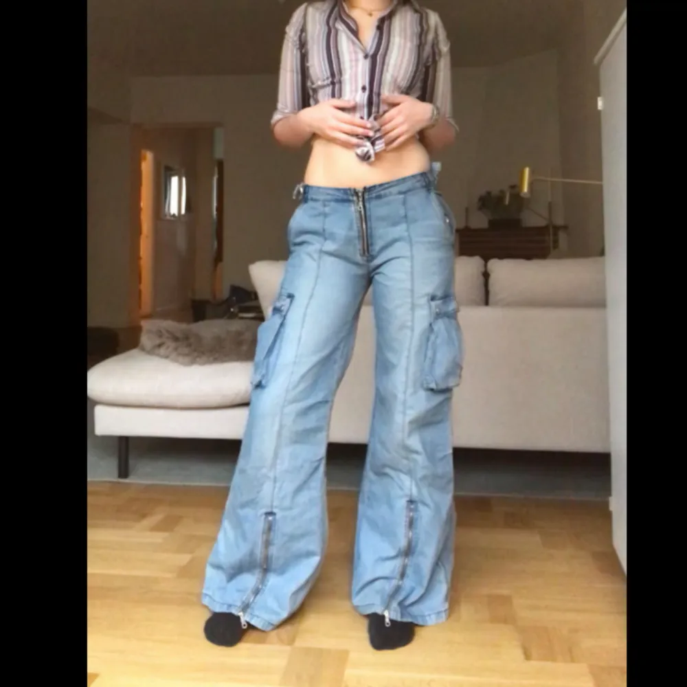 Unika Lågmidjade utsvängda jeans med drag kedjor, fickor och massa andra detaljer 🌻 Midjemått rakt över = 40 cm Innerbenslängd = 81 cm Längden på hela byxorna = 104 cm. Jeans & Byxor.