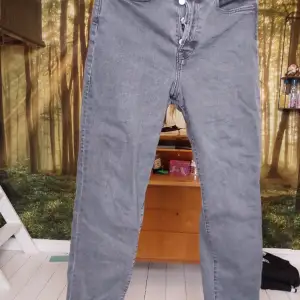 Stl. 38.  Raka jeans med hög midja. Svarta i urtvättad effekt. Som nya förutom att lädermärket lossnat i ena hörnet.